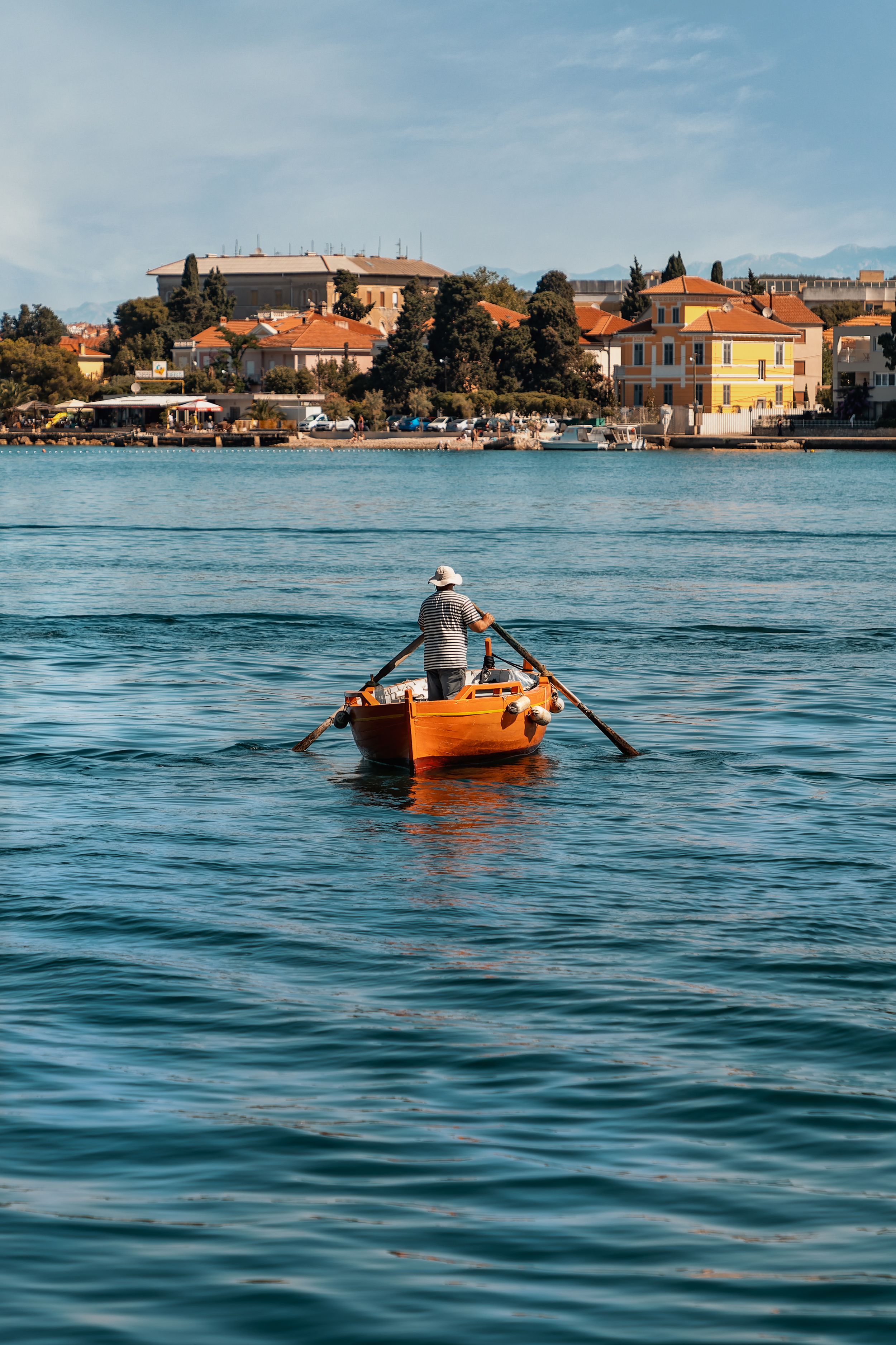 Man in a rowing boat across the harbour in Zadar, Croatia