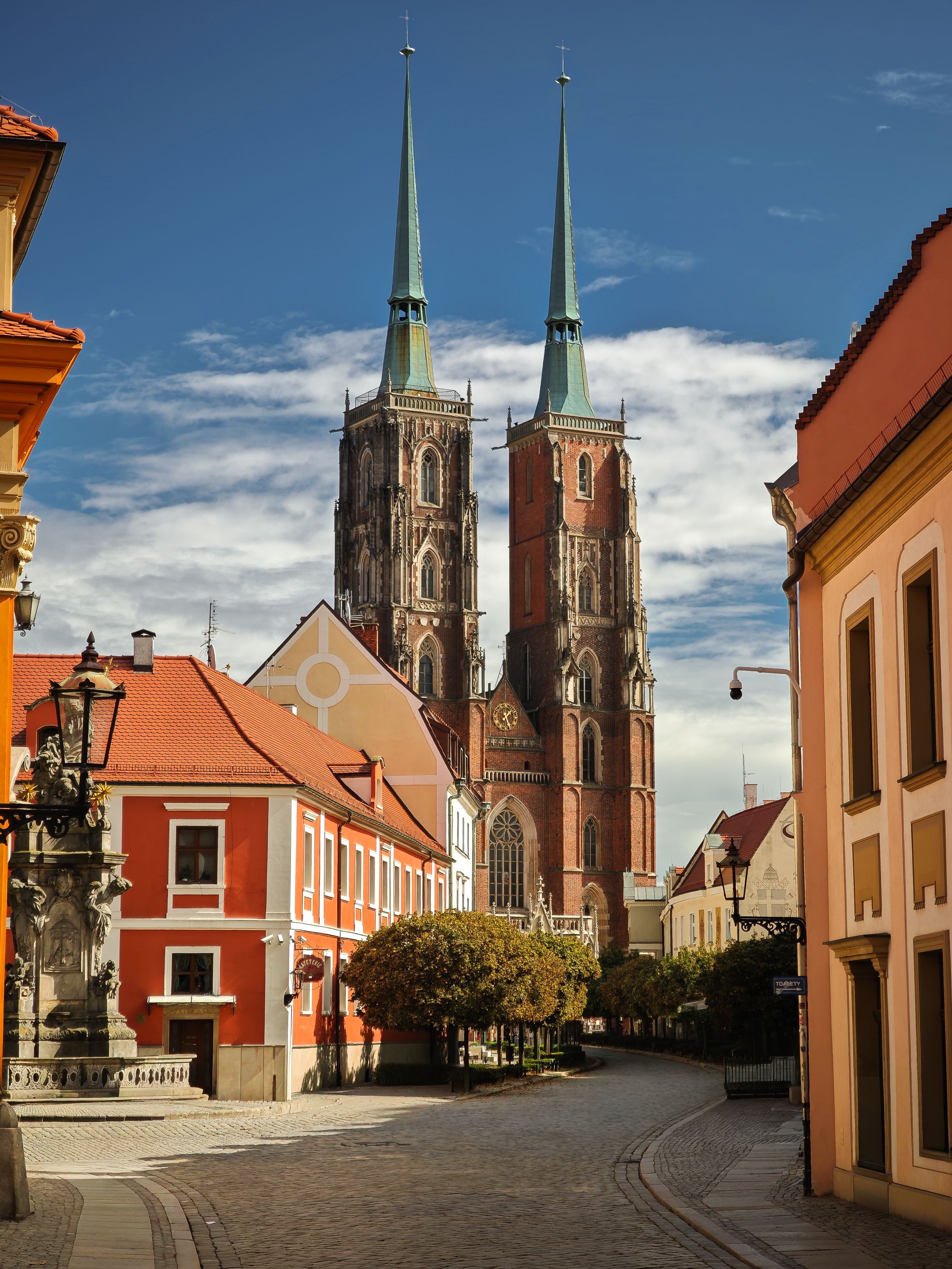 Wroclaw Cathedral with coloured buildings and blue sky at Ostrow Tumski, historic architecture photography Poland