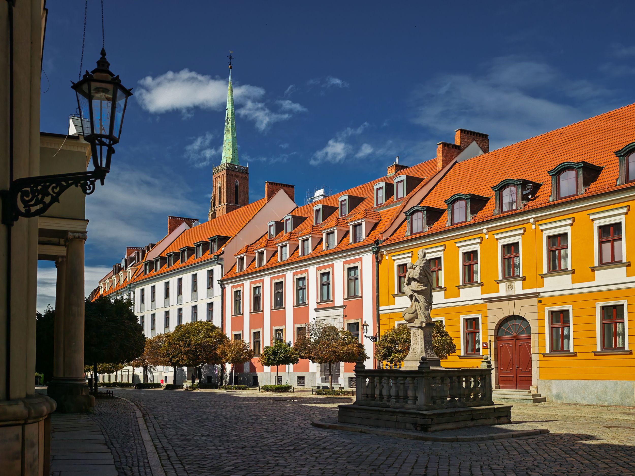 Historic colourful orange buildings with street lamp at Ostrow Tumski Wroclaw, classic cityscape architecture Poland