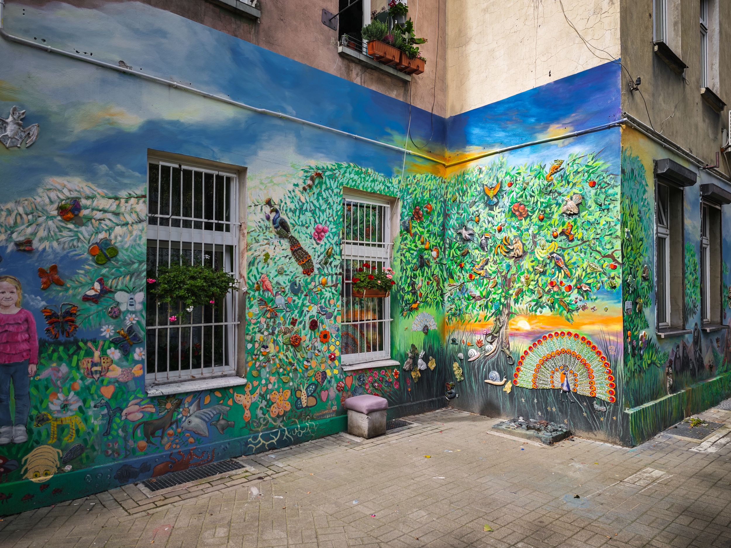 Colourful street art mural with painted faces at Nadorze Backyards Wroclaw, urban graffiti photography Poland