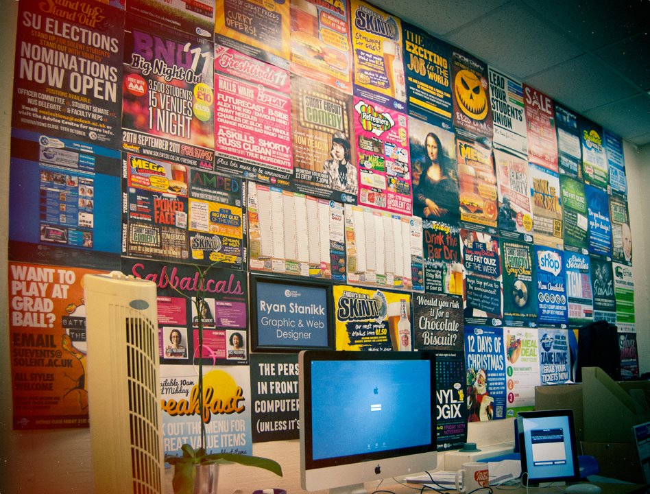 A wall covered in dozens of colourful posters and flyers designed by Ryan Stanikk at Solent Students Union